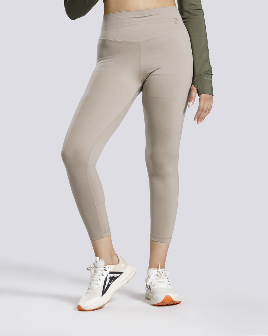 Beige leggings worn by a person on a white background